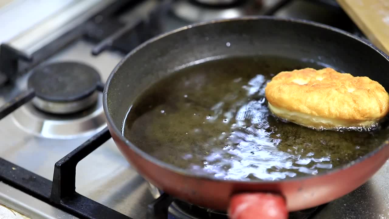 用土豆填充的馅饼，女人的手放在煎锅里滚烫的油里视频素材