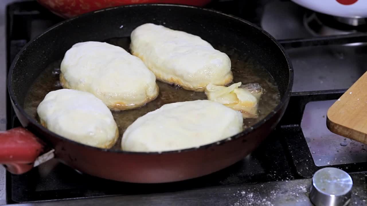 用土豆填充的馅饼，女人的手放在煎锅里滚烫的油里视频素材