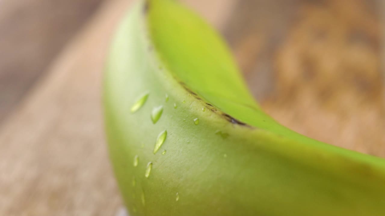 雨滴以慢动作落在绿色的香蕉上。宏视频素材