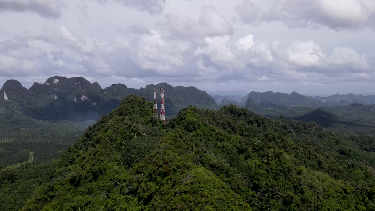 蜂窝塔鸟瞰图，无线通信技术的电信塔站在山上。空中镜头。视频素材