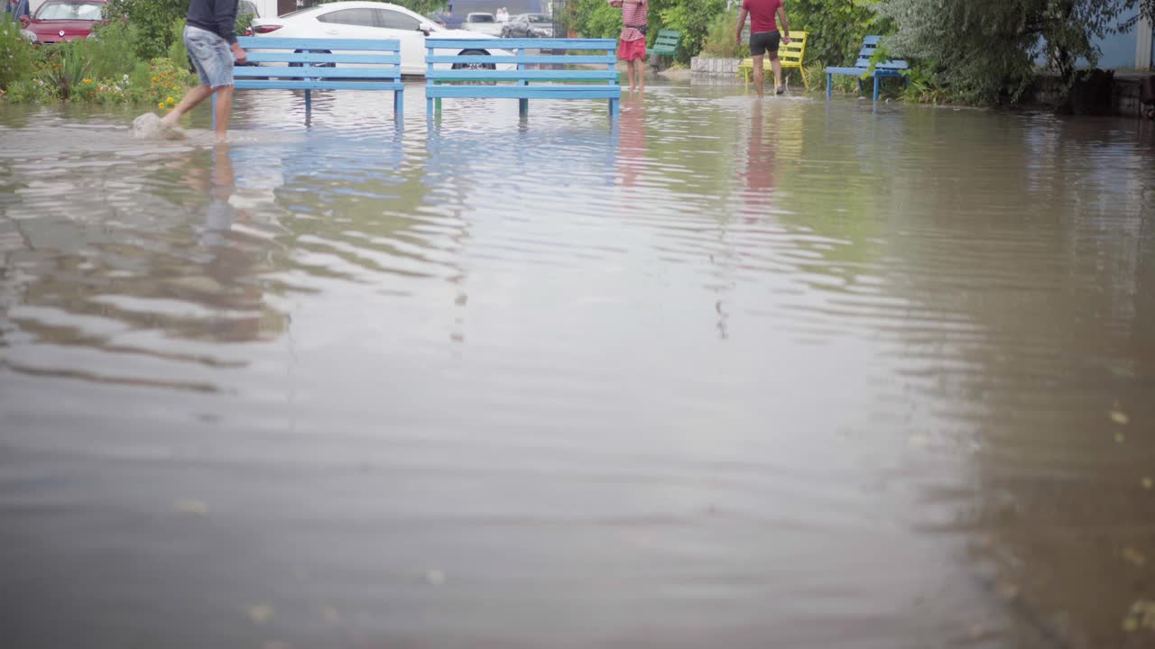 大雨过后的街道被电车淹没，人们在水上行走视频素材