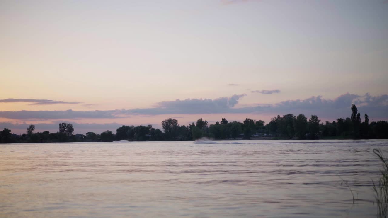 男子骑Jetski在日落湖剪影摩托艇驾驶水上自行车视频素材