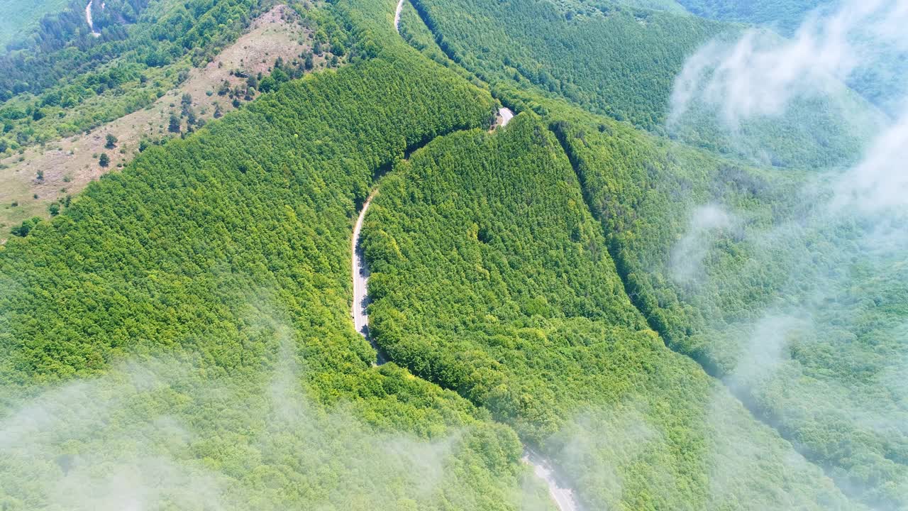 在有雾的早晨日出时，飞越高山和山峰。山脉景观航拍无人机视图。视频素材