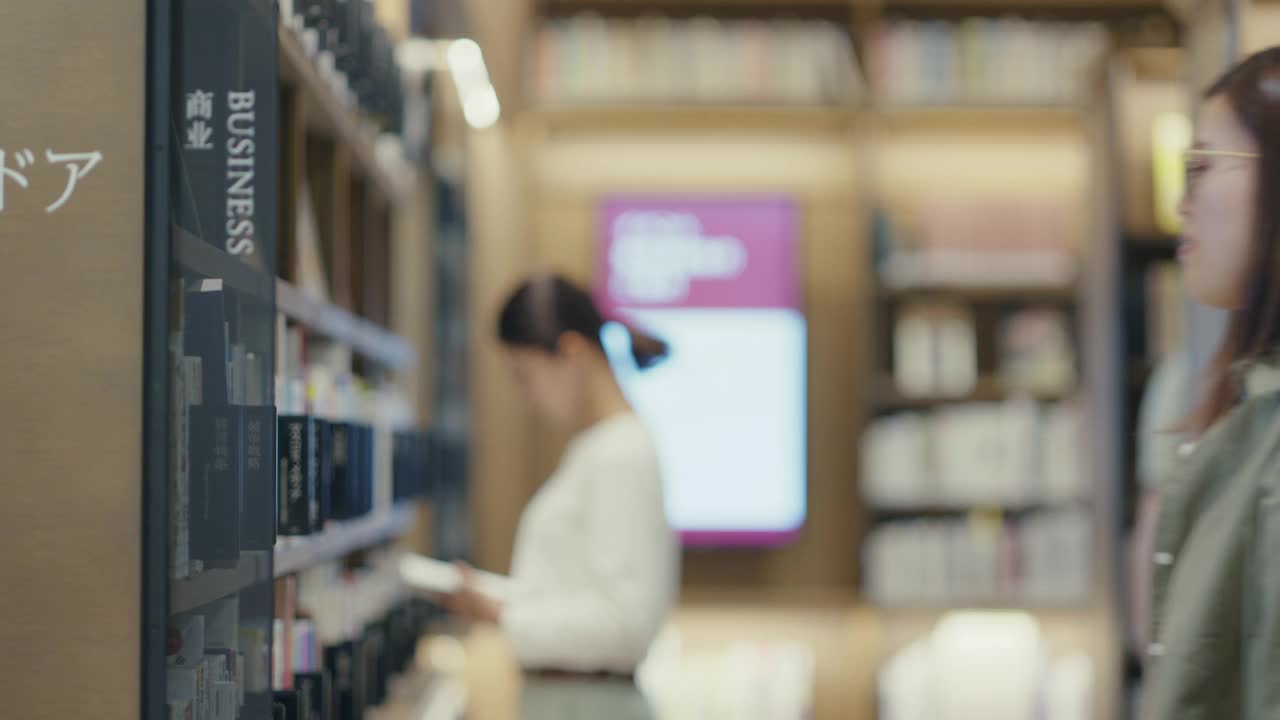 年轻的学生在图书馆阅读教科书视频素材