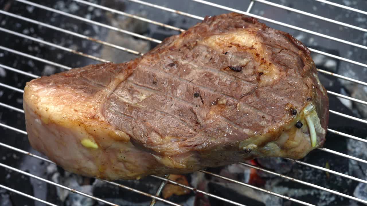 肋眼牛排牛肉烧烤与黄油和大蒜在火焰，牛肉牛排在烧烤与火焰。视频素材