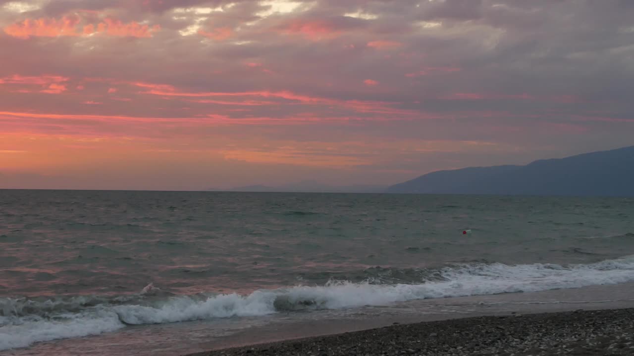 海边美丽的日落。海浪在海上，卵石滩。视频素材