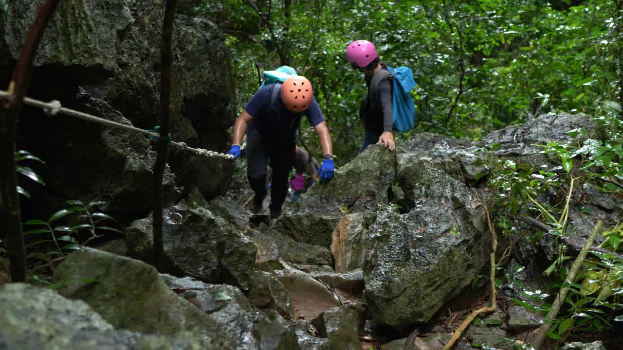 男子徒步者爬上岩石山坡的特写镜头视频素材