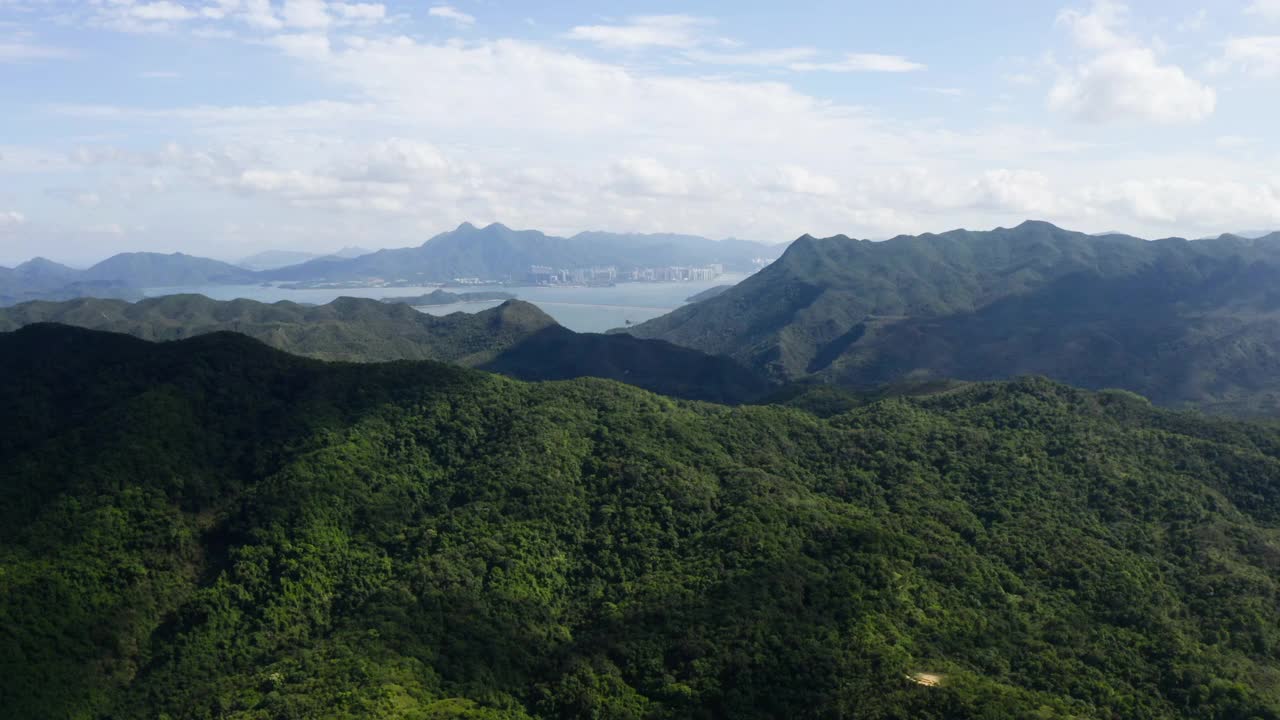 鸟瞰图，绿色的山丘和山脉在蓝天和白云的衬托下视频素材