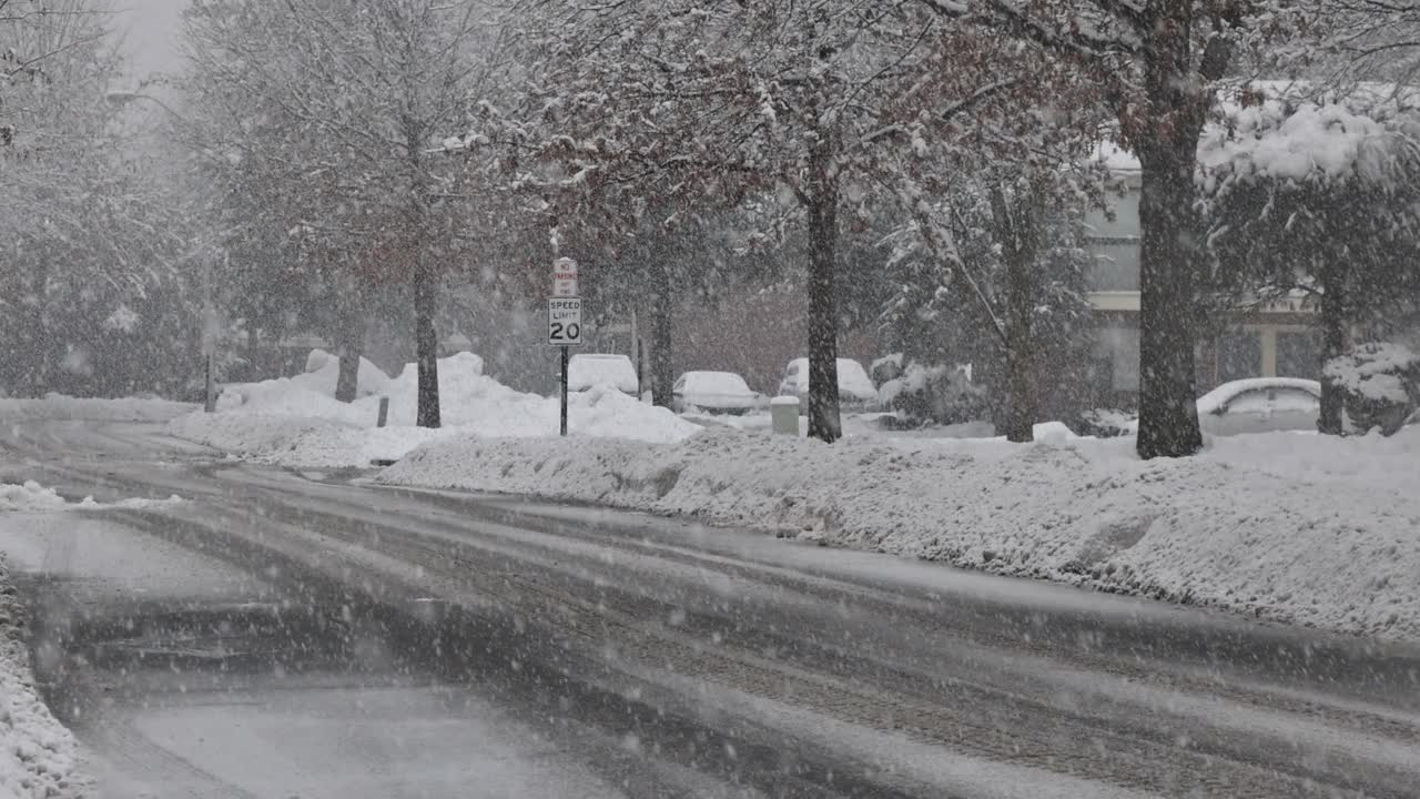 冬天风雪纷飞的白天小路上覆盖着皑皑白雪的小镇视频素材