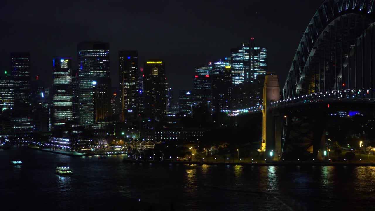 悉尼港和城市的摩天大楼在夜晚灯火通明视频素材