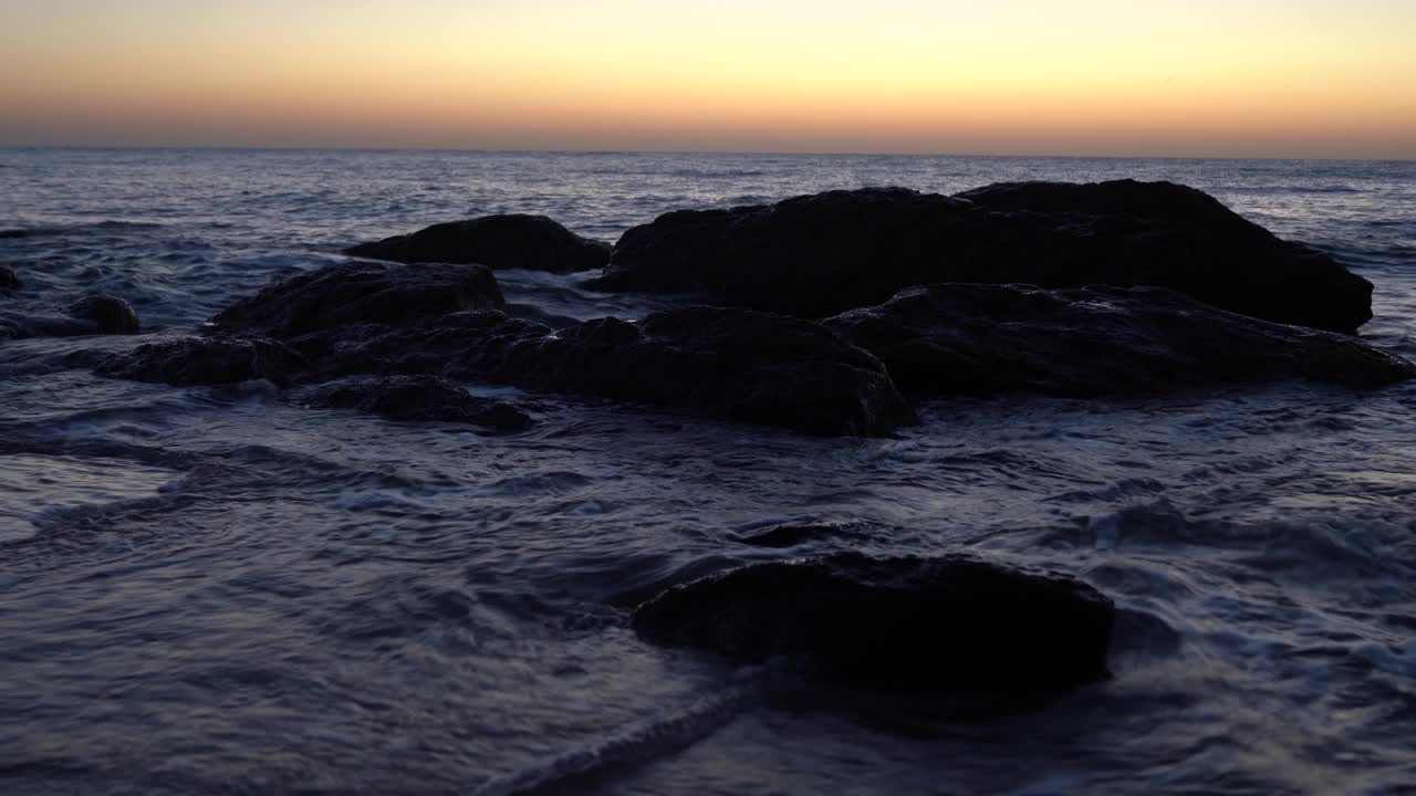 海浪拍打着卵石，逼近了。海上冲浪。波浪在海岸的卵石上冲刷。夏日海滨度假概念视频素材