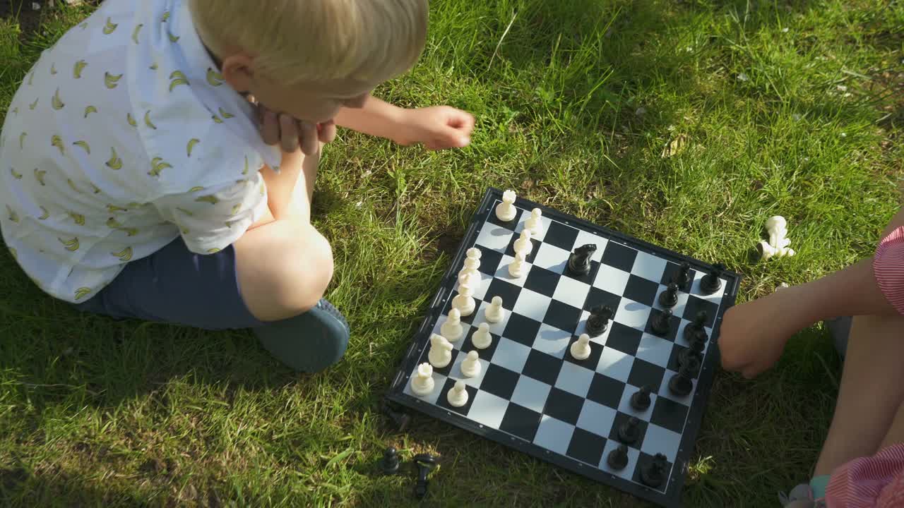 哥哥和姐姐在花园里的草地上下棋视频下载