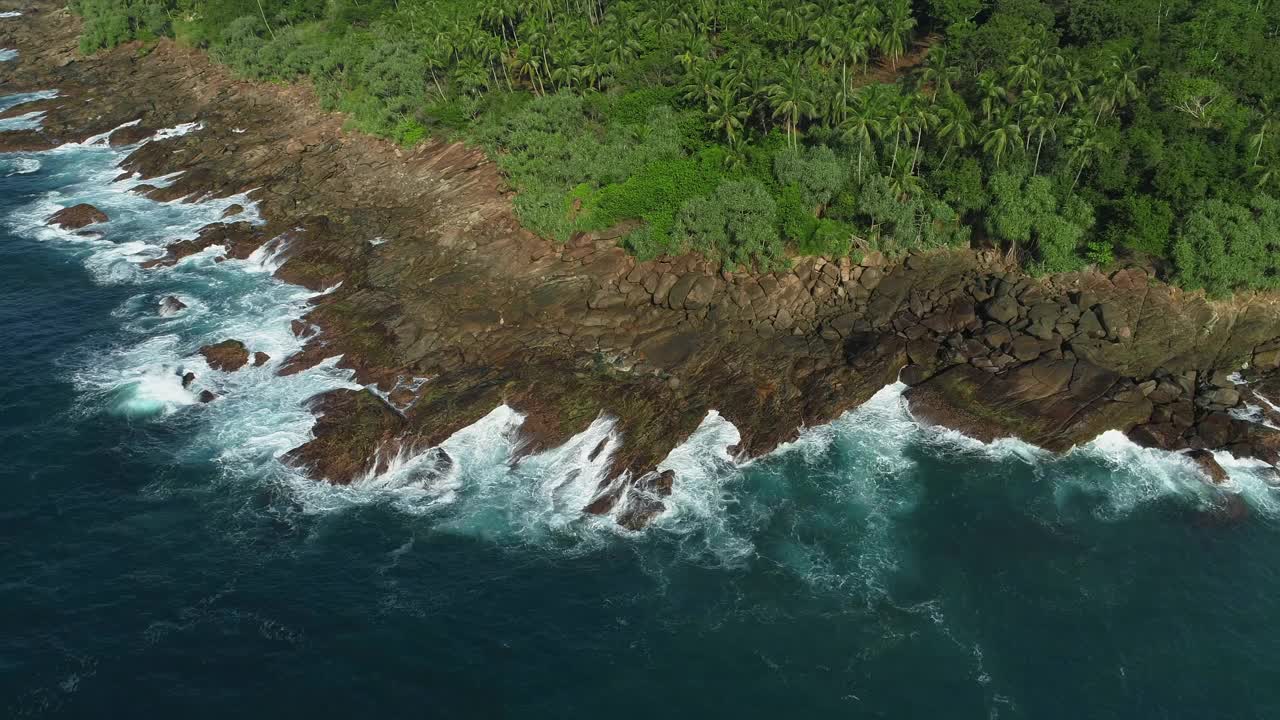 绕着岩石海岸飞行。绕着石头海角飞行。波浪拍打在石头岬上。视频素材