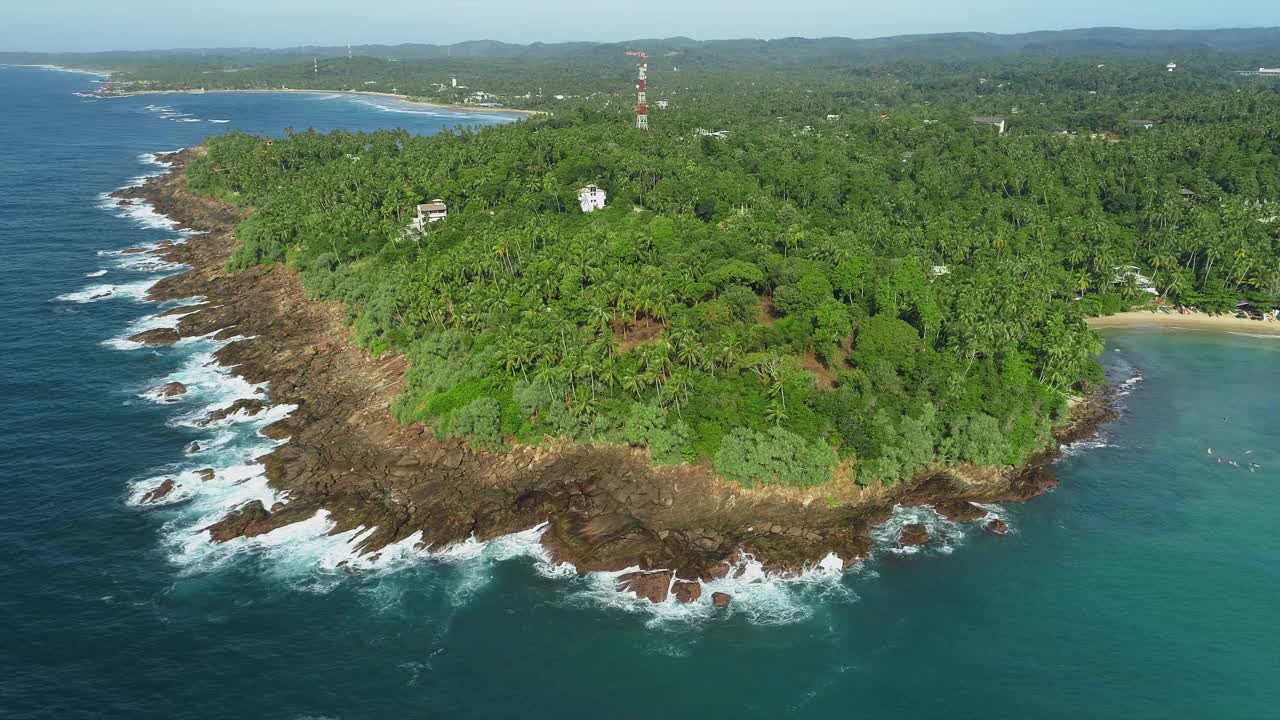 绕着岩石海岸飞行。绕着石头海角飞行。波浪拍打在石头岬上。视频素材