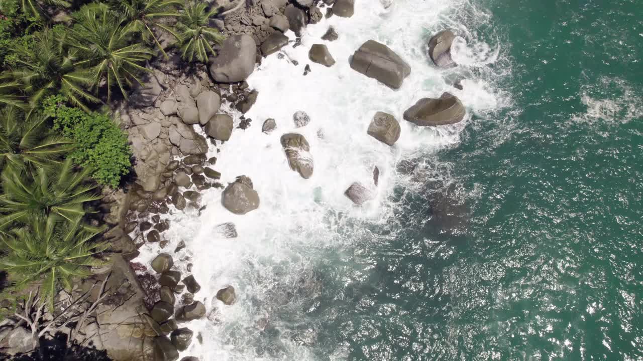 4K鸟瞰美丽的岩石海滩在阳光灿烂的日子，普吉岛，泰国。视频素材