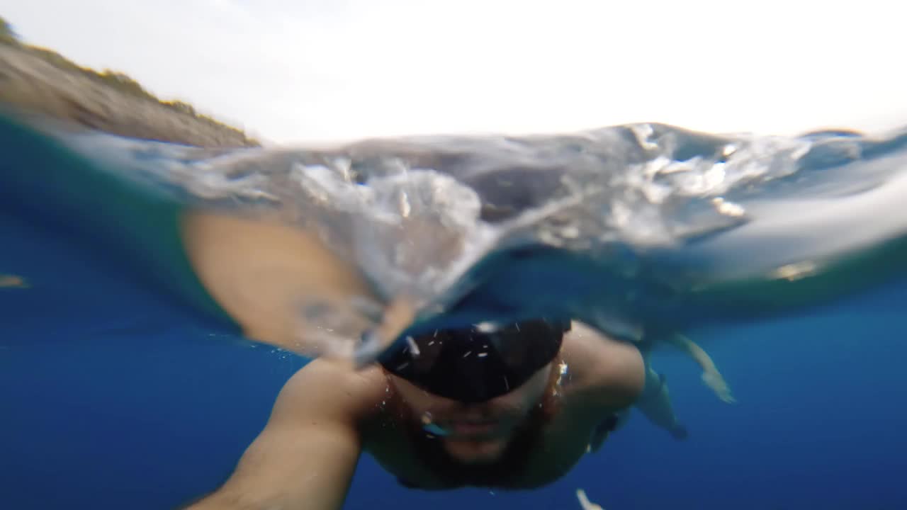 一名男子在夏日的大海中游泳和浮潜视频素材