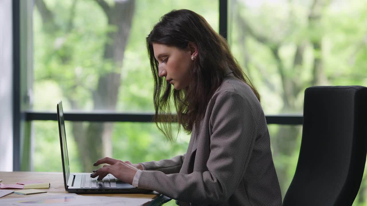 侧视图，集中白种女人在笔记本电脑键盘上打字，叹息和思考。专家经理在线消息与商业伙伴计划战略的肖像。信心和成功。视频素材