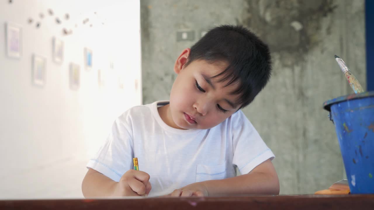 亚洲小男孩在家里或小学用铅笔在纸上画画视频素材