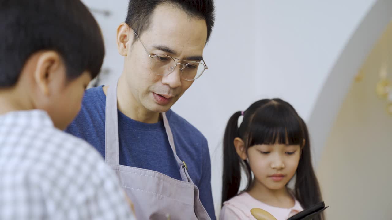 父亲和孩子一起在家做饭。视频素材