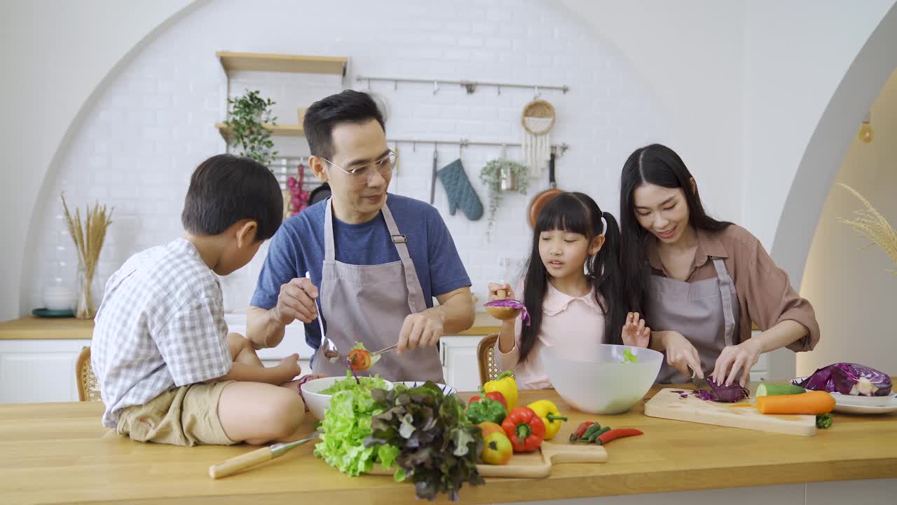 幸福的家庭，妈妈，爸爸，孩子，兄弟姐妹一起做饭。视频素材