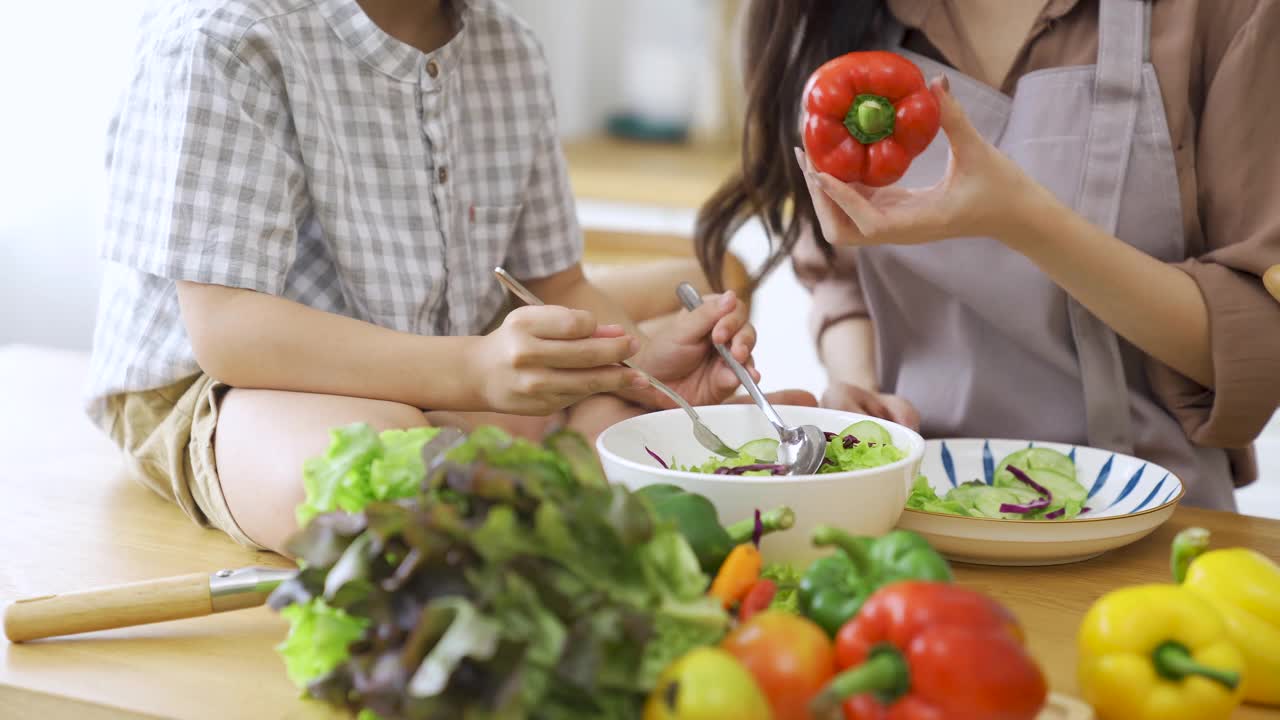 幸福的家庭，妈妈和孩子们一起做饭。视频素材