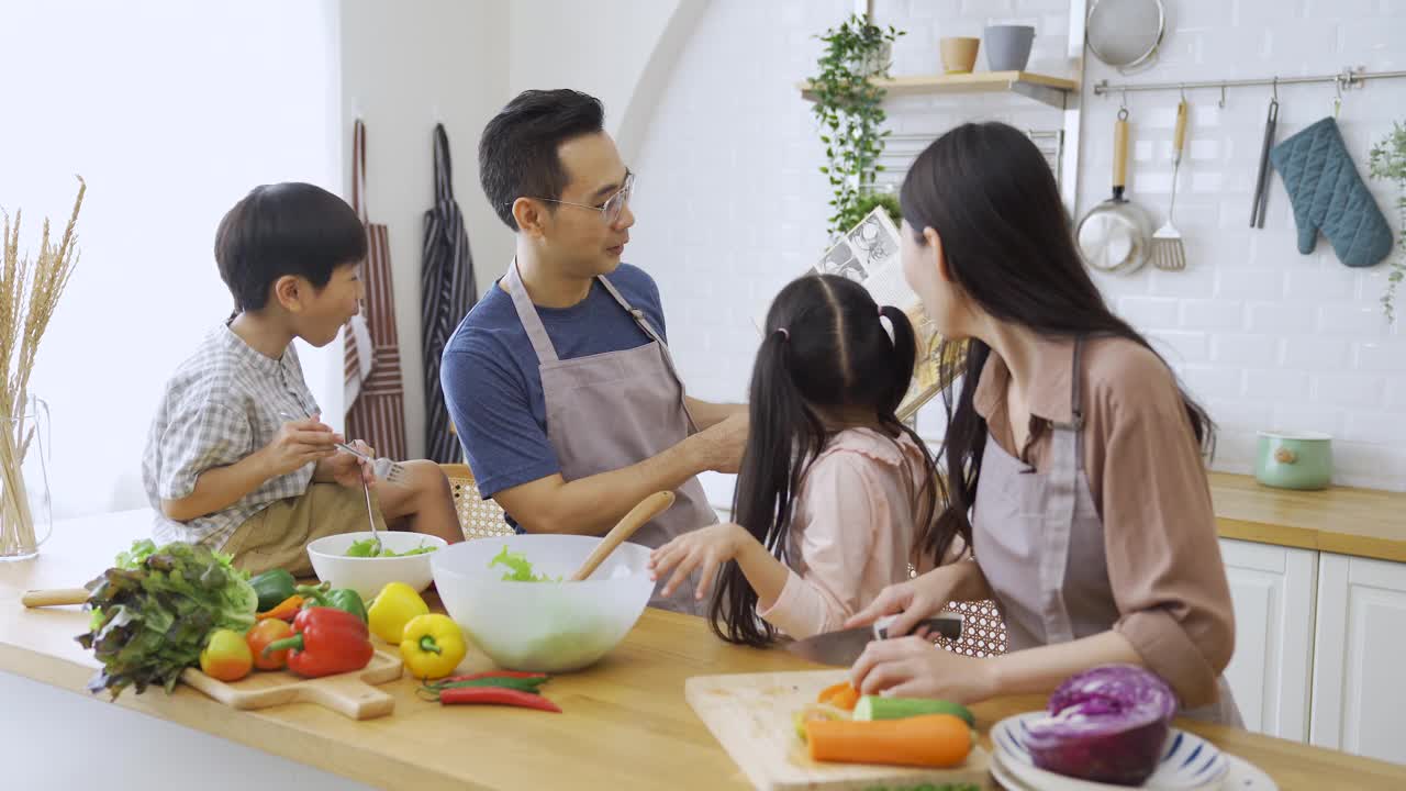 幸福的家庭，妈妈，爸爸，孩子，兄弟姐妹一起做饭。视频素材