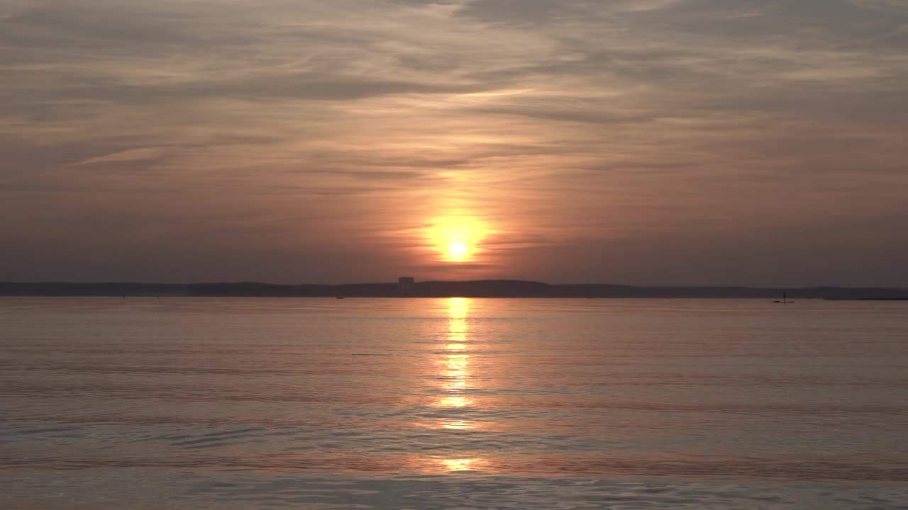 湖上的日落。在晴朗的天气里，平静温暖的夕阳落在城市外的夏日湖泊上。放松冷静自然视频视频素材