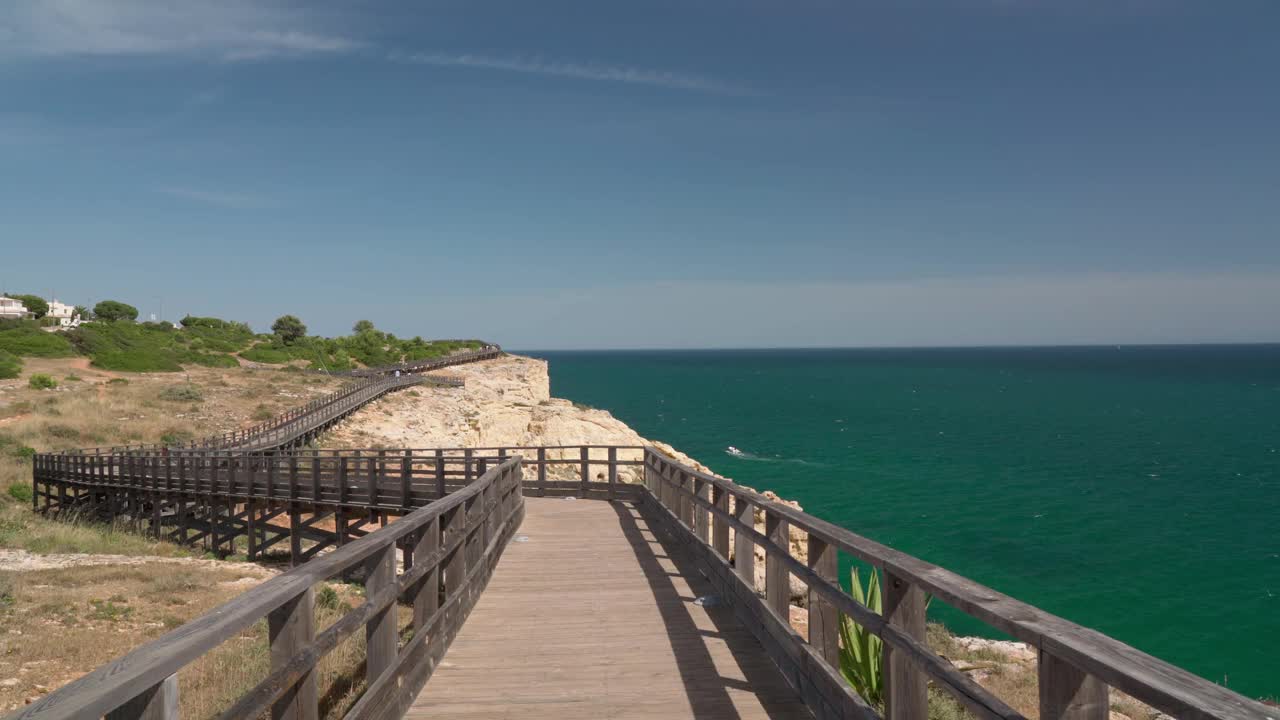 沿着木路散步，你会看到夏天葡萄牙卡沃埃罗海岸的美妙景色。俯瞰蓝色的大海。用稳定器在运动中射击。视频素材