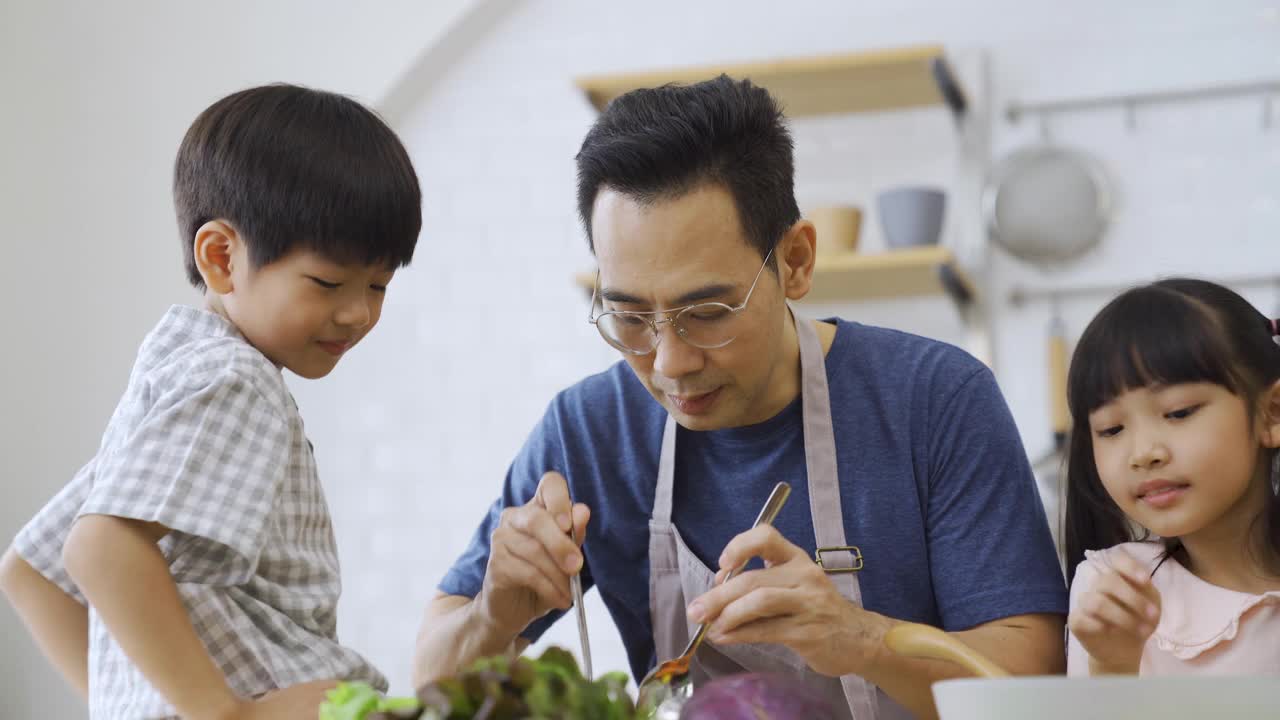 假日一家人在厨房一起做午餐。视频素材