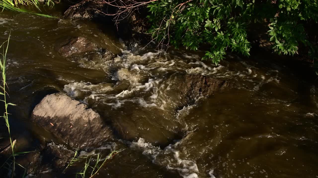 山洪灾害时，山河浑浊的水流在花岗岩间流动视频素材