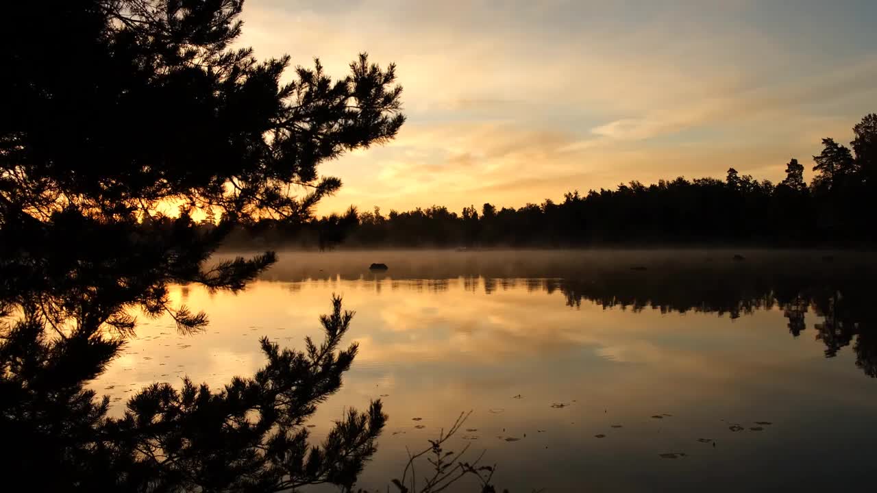 一个秋天的日出，在平静的湖边视频素材