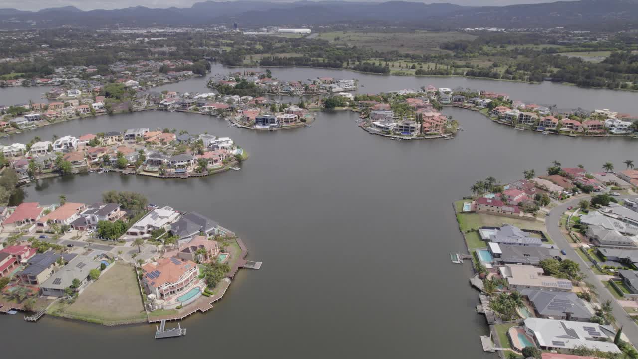 无人机飞向/穿过澳大利亚黄金海岸的豪华住宅运河住宅郊区视频素材