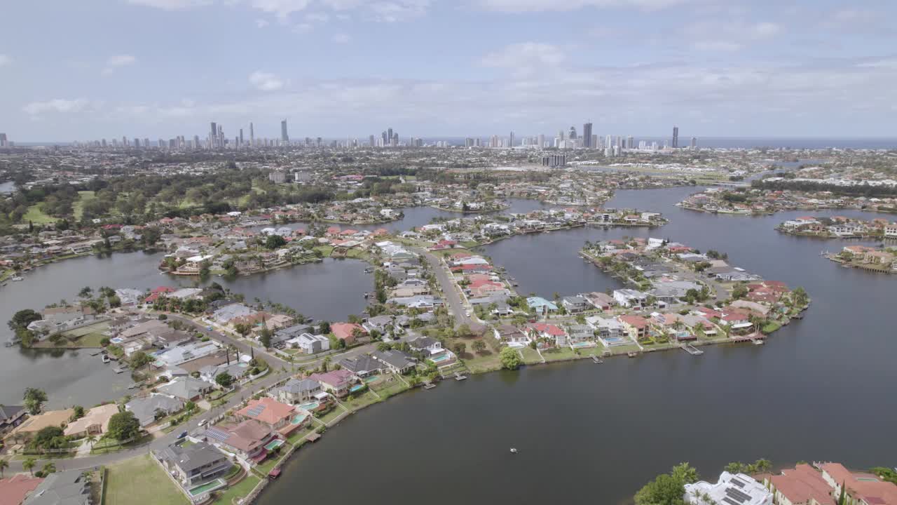 空中移动-海滩/旅游城市天际线与住宅运河郊区前景，黄金海岸，昆士兰州，澳大利亚视频下载