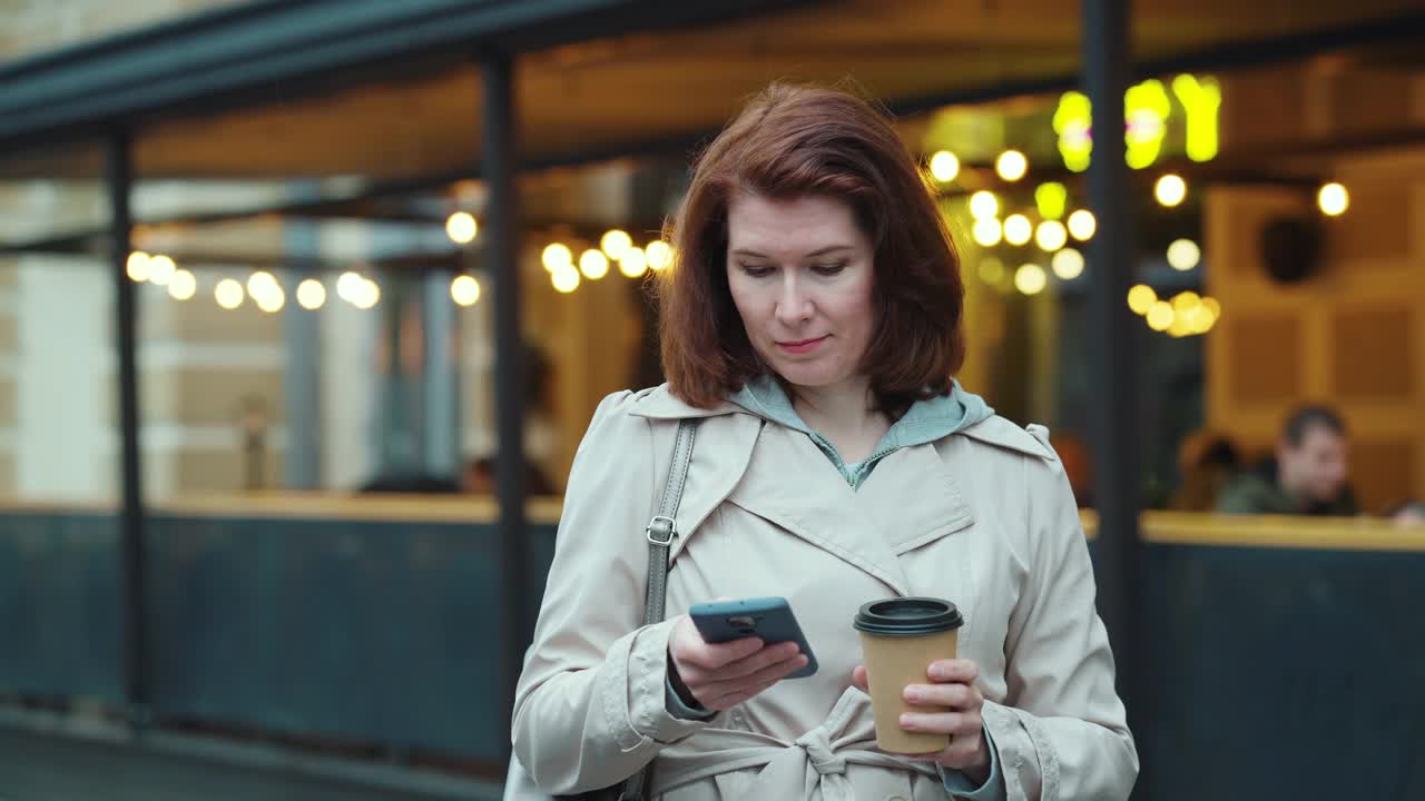 女人拿着咖啡杯发短信视频素材