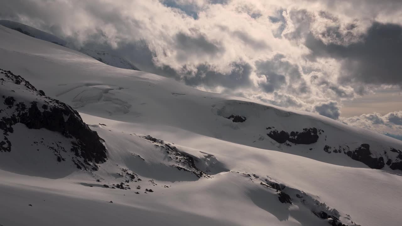 时间推移坡是指太阳落山前南方云杉带着风和雪的移动。高海拔积雪时间间隔。改变山区的天气视频素材