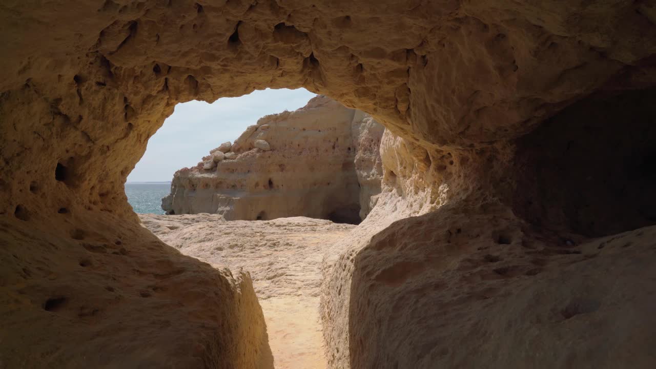 沿着葡萄牙海岸阿尔加维区(Carvoeiro)的山石小径和隧道行走。视频素材