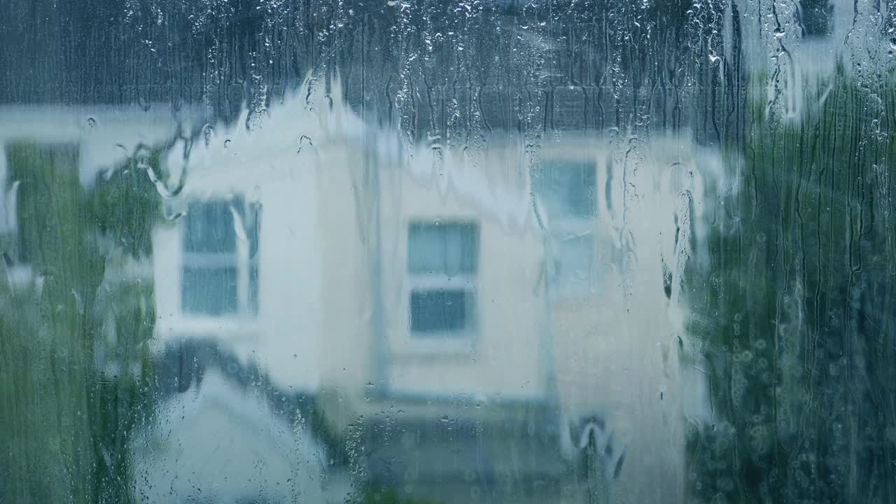 雨从窗户上落下，背景是房子视频素材