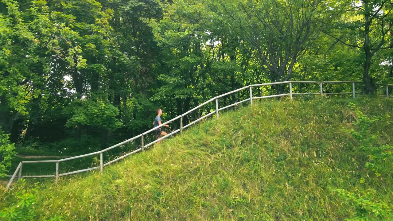 那人飞快地跑过树林。清晨的春天在绿色的森林里奔跑视频素材