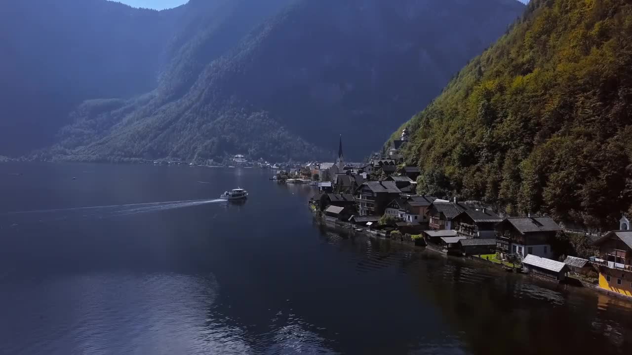 在阳光明媚的夏日早晨，在上奥地利州萨尔斯卡默古特的哈尔斯塔特村上空飞行，速度从24帧提高到2.5倍。视频素材