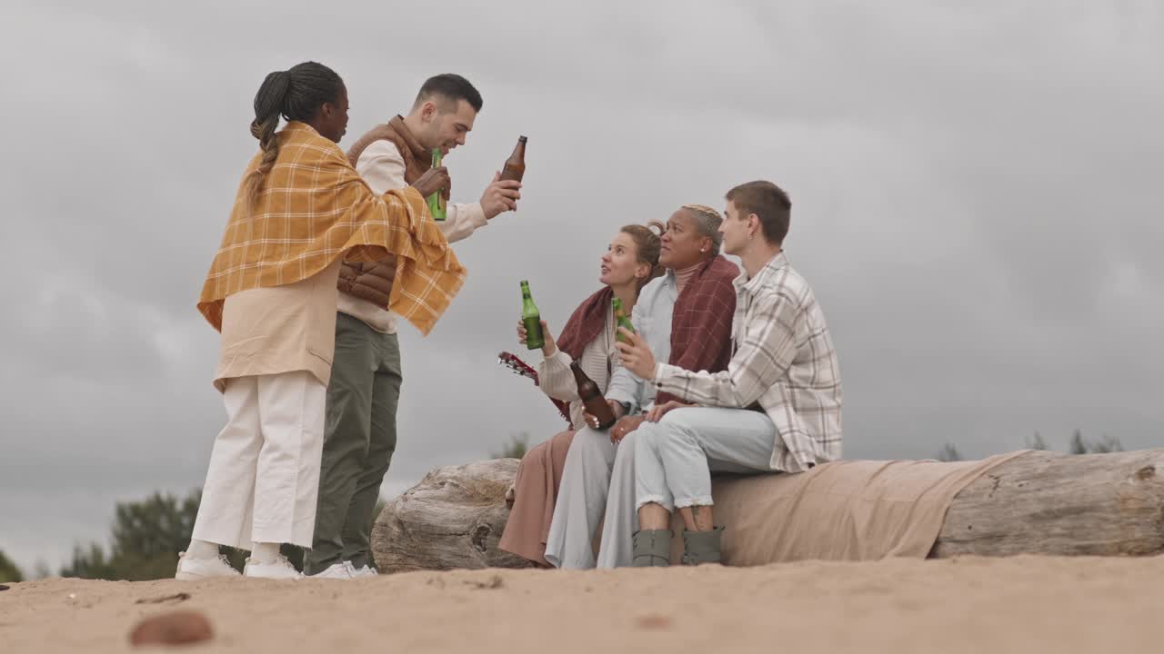 年轻人在海滩上喝啤酒视频素材