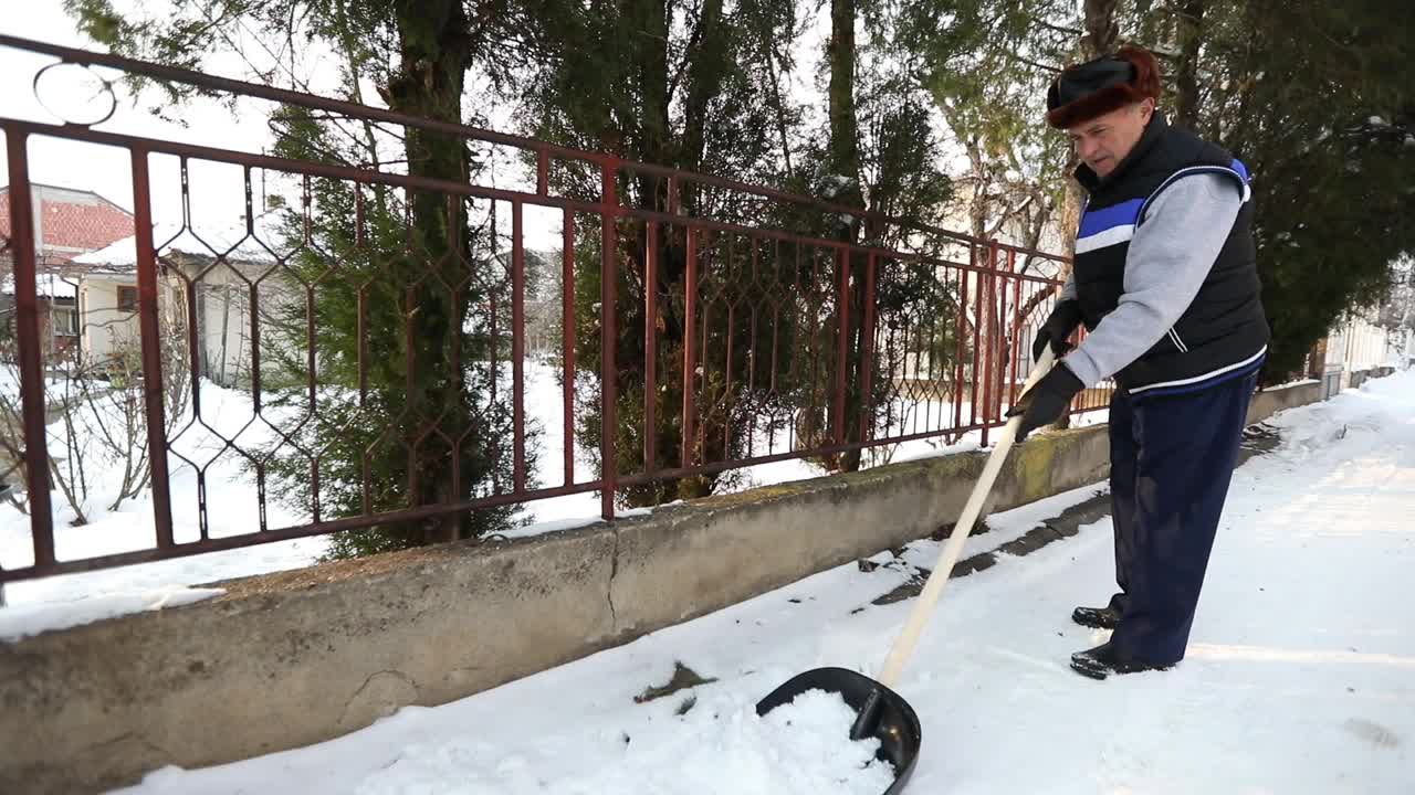 清扫积雪的老人视频素材