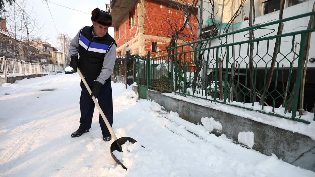 清扫积雪的老人视频素材