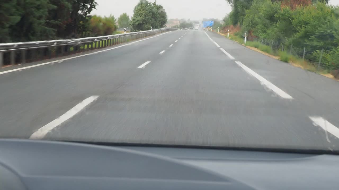 车的观点行驶在下雨的公路和挡风玻璃雨刷擦雨视频素材