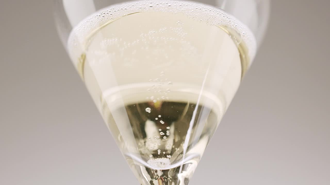 一颗干净的葡萄掉入白色背景的香槟杯中视频素材