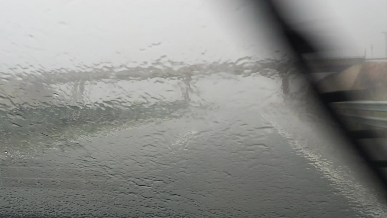 汽车视角行驶在下雨的公路和挡风玻璃雨刷清理从一个大而强烈的风暴的雨视频素材