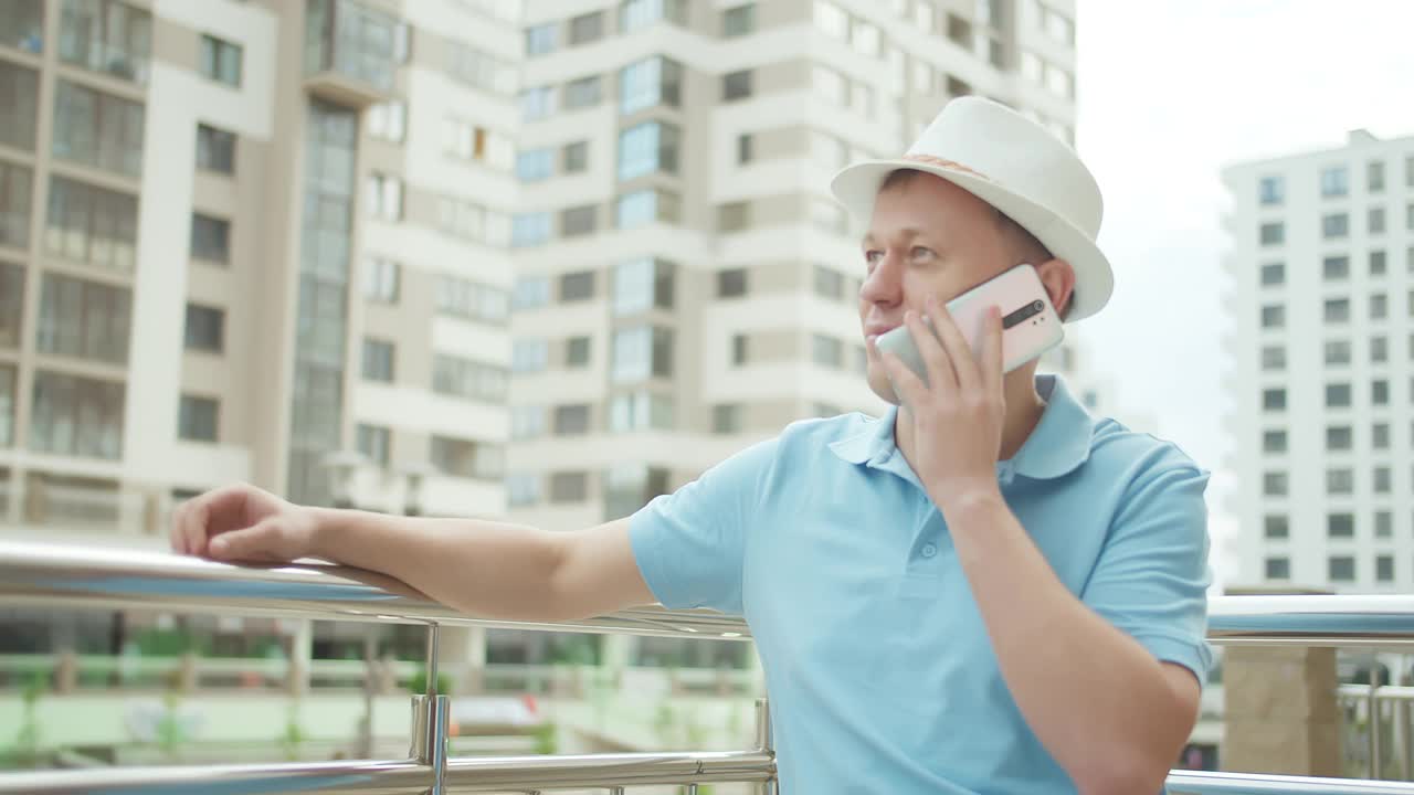 一个年轻人在摩天大楼的背景下打电话视频素材