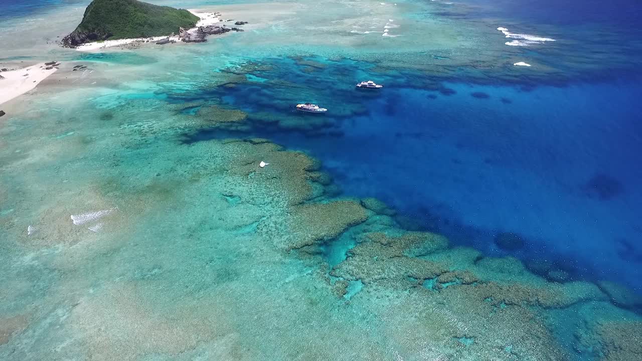 飞越原始的无人居住的冲绳岛俯瞰渔船视频素材