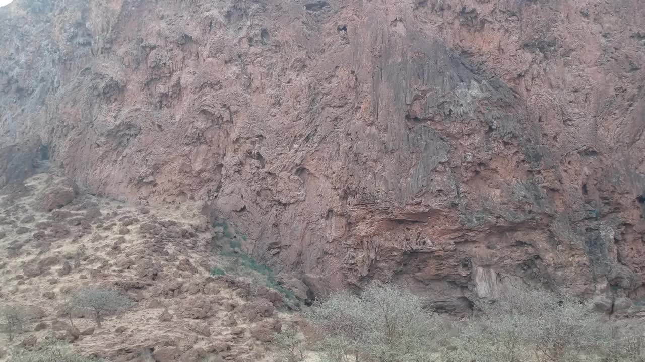 水侵蚀模式上的一个干的瀑布相机沿着悬崖面缓慢地上升航拍视频视频素材