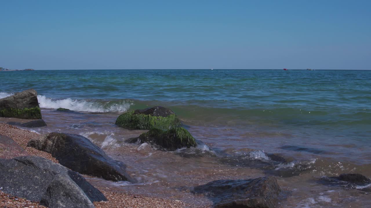 海边有沙子和大石头。海滩上强劲海浪的美丽景色视频素材