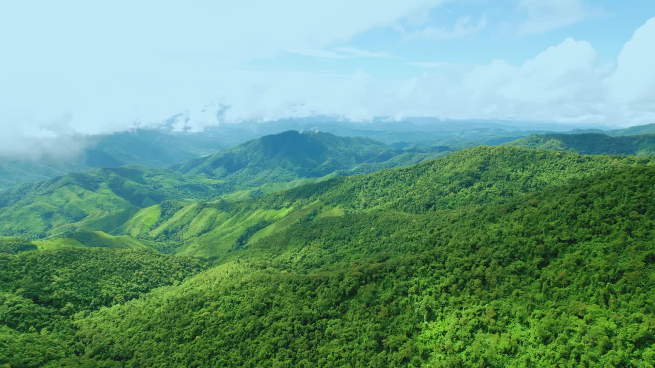 鸟瞰无人机拍摄的流动的雾波在山区热带雨林在晚上，鸟瞰图像在云上惊人的自然背景与云和山峰。视频素材